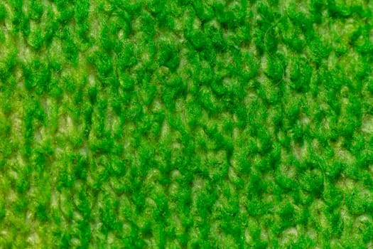 Dark green background from a textile material with wicker pattern, closeup. Structure of the emerald fabric with texture. Soft cloth backdrop.