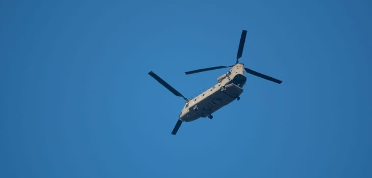 big chinook helicopter flying with blue sky as background