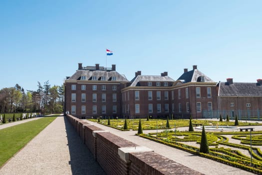 Palace Het Loo in Apeldoorn, The Netherlands with the dutch flag red white blue on top