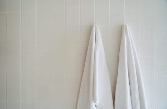 Two white towels hanging in the hotel shower room. High quality photo