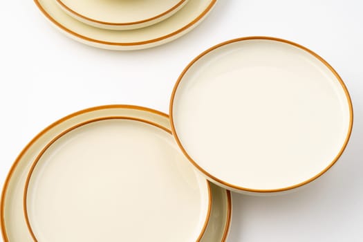 A set of white and brown ceramic plate and bowl on a white background