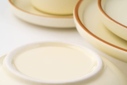 A set of white and brown ceramic plate and bowl on a white background. Close-up