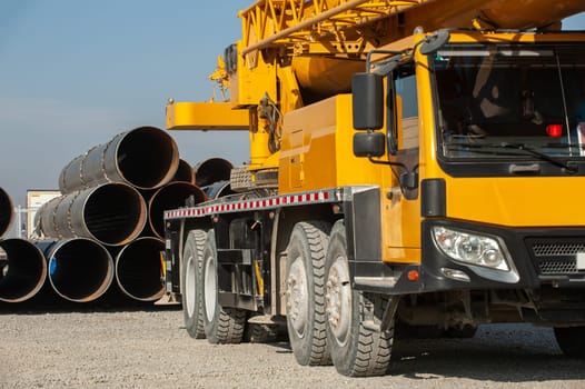 A side shot of a yellow crane in an industrial construction area