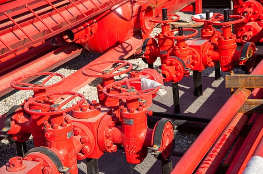 A closeup of a red industrial oil pipeline valves