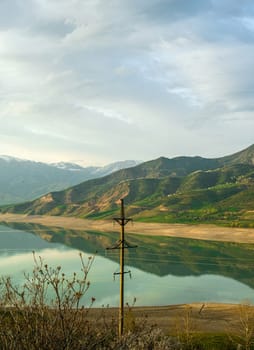 A vertical shot of the mountains and a reservoir in Central Asia