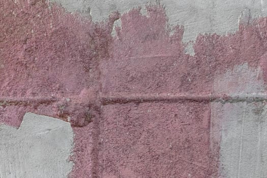 Old wall of concrete blocks in pink paint and cement stains texture background repair construction.