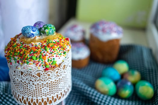 Easter cake with glace icing decoration and colored easter eggs on a holiday table