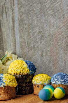 Delicious Easter cakes on a wooden table with flowers in the background. place for text. selective focus