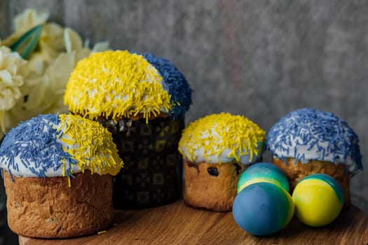 Delicious Easter cakes on a wooden table with flowers in the background. place for text. selective focus