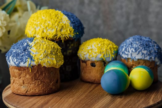 Delicious Easter cakes on a wooden table with flowers in the background. place for text. selective focus