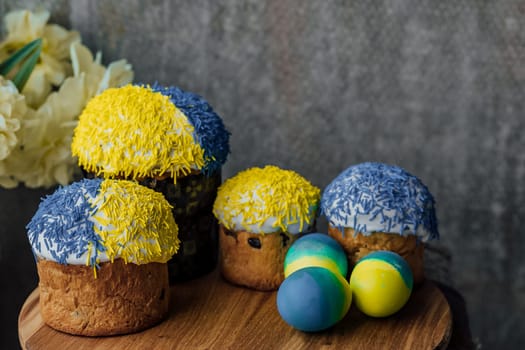 Delicious Easter cakes on a wooden table with flowers in the background. place for text. selective focus