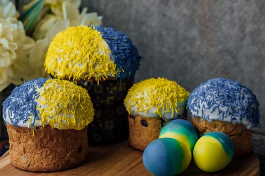 Delicious Easter cakes on a wooden table with flowers in the background. place for text. selective focus