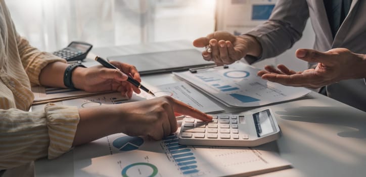 Two business people talk project strategy at office meeting room. Businessman discuss project planning with colleague at modern workplace while having conversation and advice on financial data report