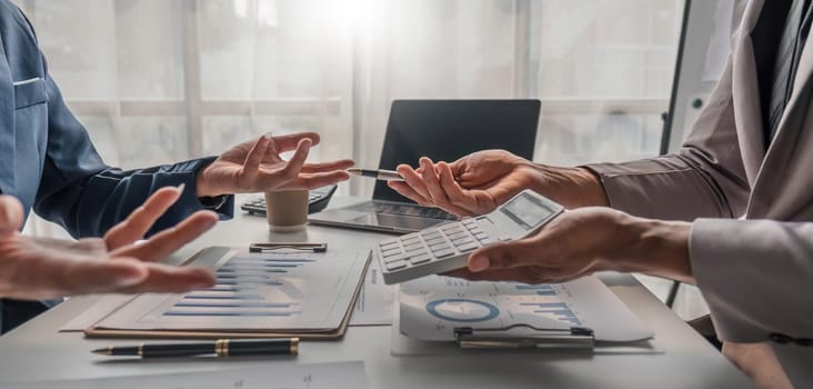 Two business people talk project strategy at office meeting room. Businessman discuss project planning with colleague at modern workplace while having conversation and advice on financial data report