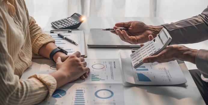 Two business people talk project strategy at office meeting room. Businessman discuss project planning with colleague at modern workplace while having conversation and advice on financial data report