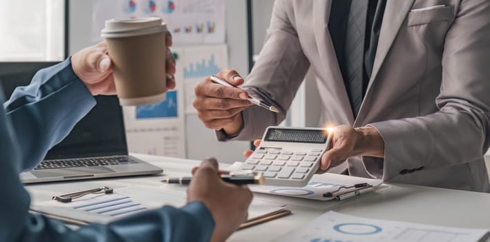 Two business people talk project strategy at office meeting room. Businessman discuss project planning with colleague at modern workplace while having conversation and advice on financial data report