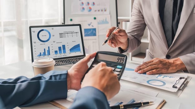 Two business people talk project strategy at office meeting room. Businessman discuss project planning with colleague at modern workplace while having conversation and advice on financial data report