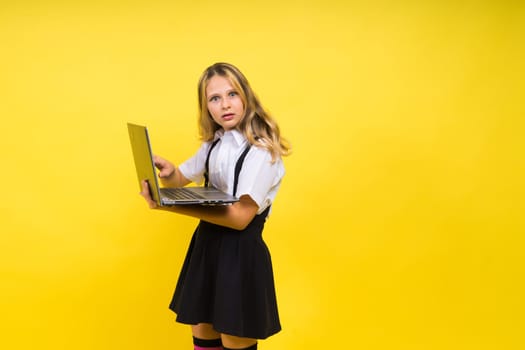 Little blonde kid girl on a pastel yellow wall background. Childhood lifestyle concept.