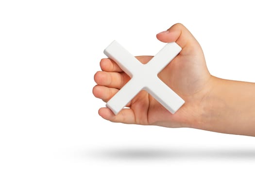 White multiplication symbol or cross in hand. The concept of prohibition or removal of something. Mathematical white multiplication symbol in hand on a white isolated background.