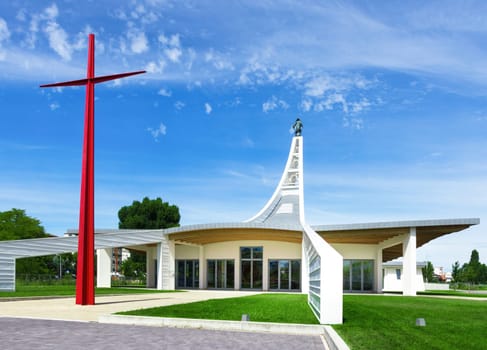 Modern church with a big red cross in Italy