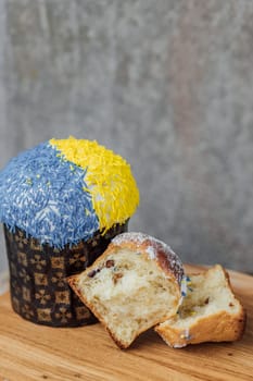 Easter cake is decorated with yellow-blue sprinkles on a gray background. place for text. patriotic paska in the color of the flag of Ukraine.