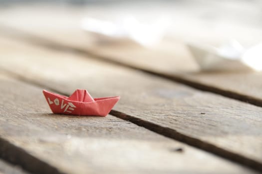 Love idea. Beautiful paper boats on a vintage wooden background.