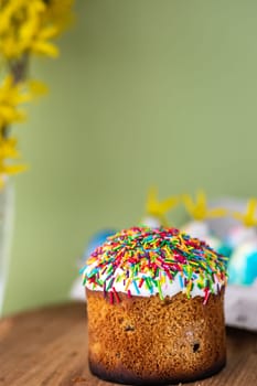 Easter cake on a yellow, light green background and yellow spring flowers. easter colored eggs. Easter food. minimal concept