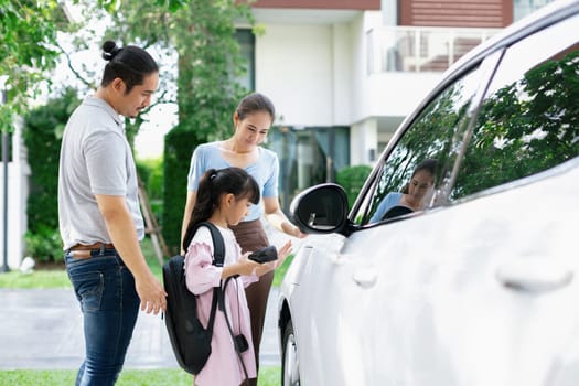 Progressive young happy family with electric vehicle and home backyard charging station. Green and clean energy from electric vehicles for healthy environment. Eco power from renewable source.