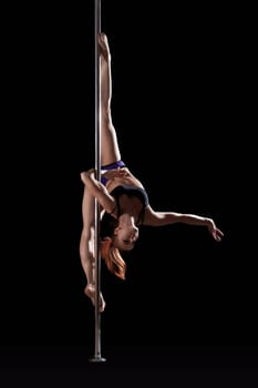 Flexible slim pole dancer posing on split, upside down