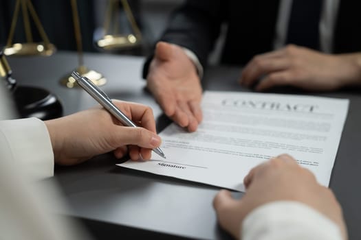 Closeup businessman sign contract or legal document with pen in his hand during corporate meeting for business deal or legal executive decision to pay off a loan or filing for bankruptcy. Equilibrium