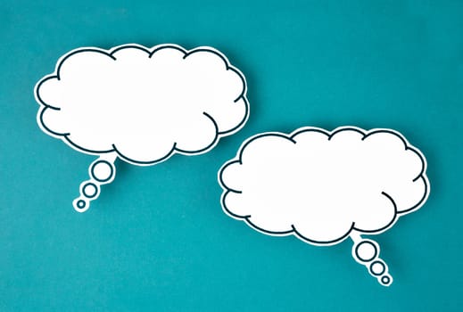 White speech bubble shaped post it note on green background with copy space.