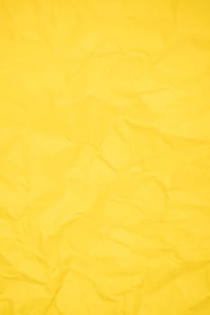 Abstract vertical yellow color creased paper texture as background.