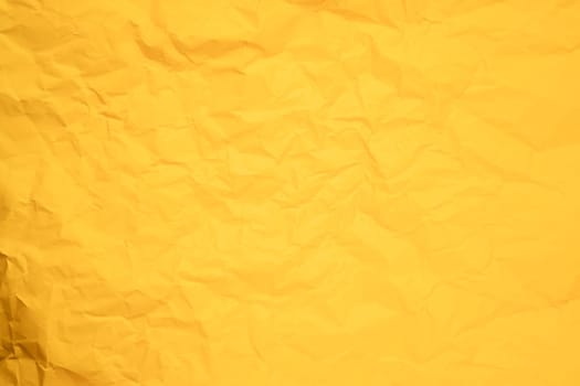 Abstract background from crumpled yellow paper texture.