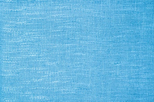 Close up shot of colored light blue fabric texture as background.