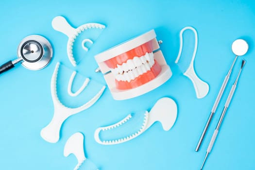 Teeth model and instrument dental on blue background.