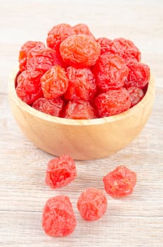 Dried red prunes fruits (Preserved fruits Chinese plum) in wooden bowl on wooden background.