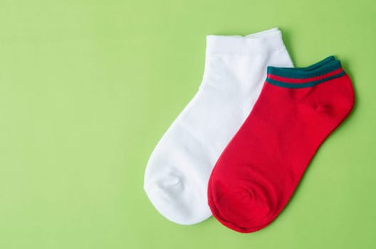 Red and white color Socks on green background.