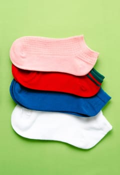 Socks of different colors on yellow color background.