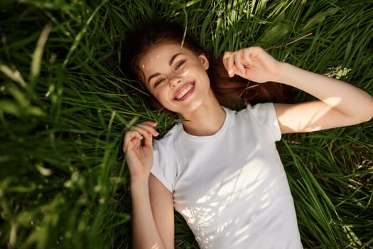 portrait of smiling happy woman with teeth on the grass. High quality photo