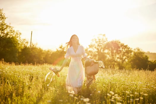 silhouette of a running woman in a light dress running across the field in the rays of the setting sun. High quality photo