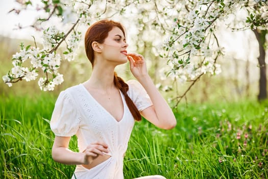 beautiful young readhead woman standing near the apple tree. High quality photo