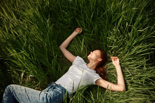 joyful woman resting in tall grass during sunset. High quality photo