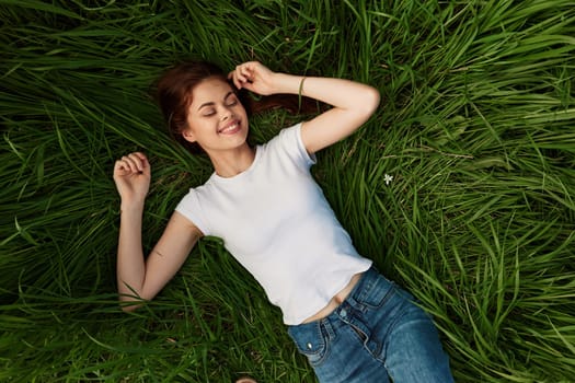 Woman dreams, lies in the grass . High quality photo