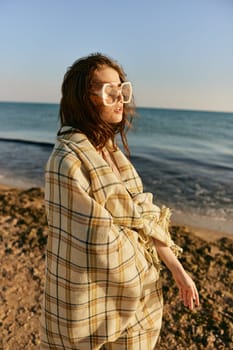 portrait of a woman with a plaid on a warm, sunny, summer day on the beach. High quality photo