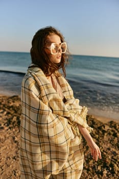 portrait of a woman with a plaid on a warm, sunny, summer day on the beach. High quality photo