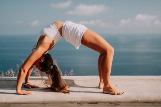 Fitness woman sea. Outdoor workout on yoga mat in park near to ocean beach. Female fitness pilates yoga routine concept. Healthy lifestyle. Happy fit woman exercising with rubber band in park.