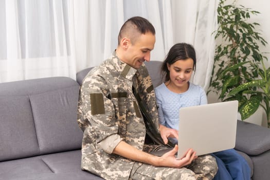 Happy girl sitting with military man near laptop