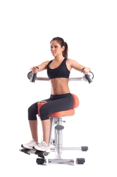 Pretty athletic girl exercising on isodynamic simulator
