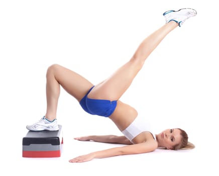Image of flexible young girl exercising on stepper in studio