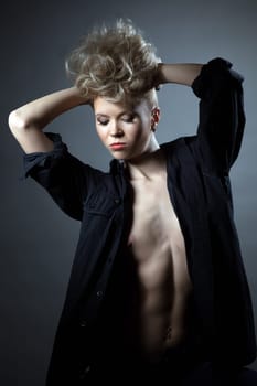 Portrait of angry young blond posing topless in black shirt